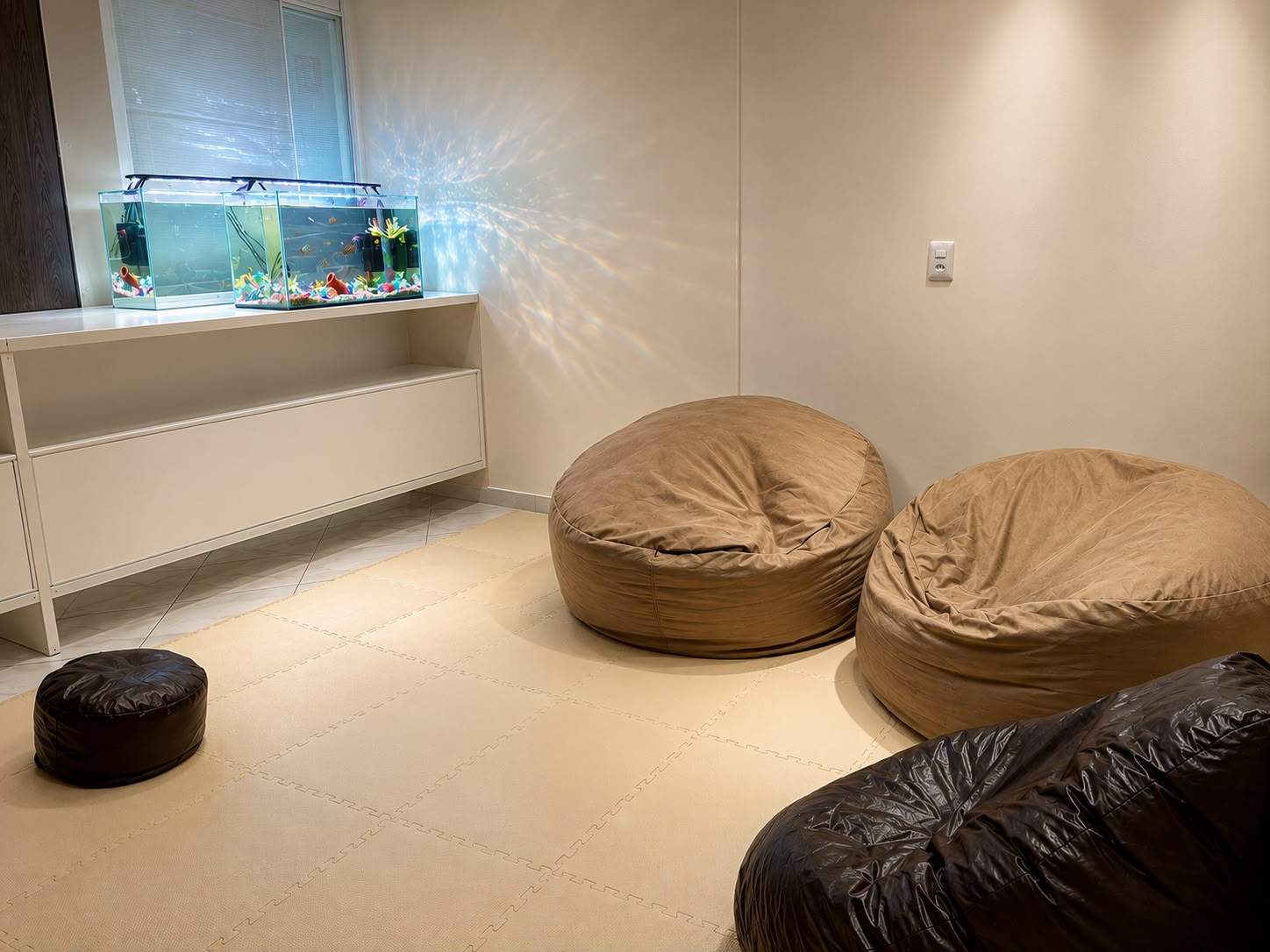 Sala de integração sensorial com puffs e aquários